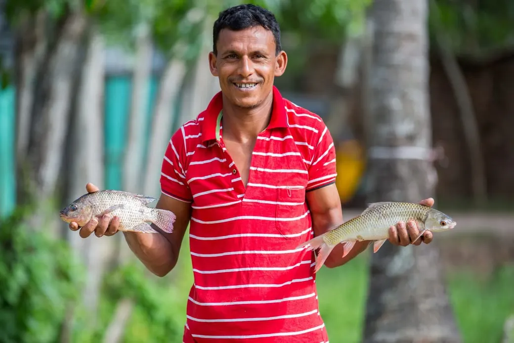 Fish farmer holding freshly harvested fish